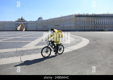 Employee of Yandex delivers foods on an empty Palace square in the center of St. Petersburg, Russia, on April 7, 2020. Russian President Vladimir Putin signed a decree on days off until April 30. Citizens are asked to observe a self-isolation regime in order to prevent the spread of the coronavirus (covid-19). (Photo by Valya Egorshin/NurPhoto) Stock Photo