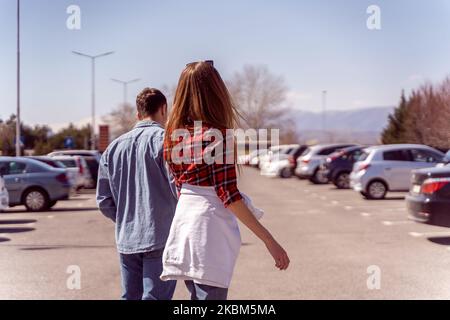 Cute couple posing from  the back at the parking Stock Photo