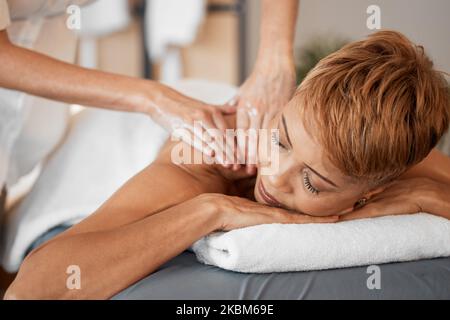 Spa, wellness and black woman getting luxury back massage for health, beauty and healing treatment. Salon, peace and calm lady relaxing with therapy Stock Photo