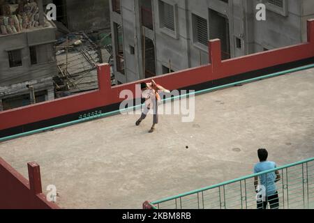 Children playing cricket on the rooftop of a building during government-imposed lockdown as a preventive measure against the COVID-19 coronavirus in Dhaka, Bangladesh on April 10, 2020. (Photo by Zakir Hossain Chowdhury/NurPhoto) Stock Photo