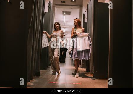 Two teenage  pretty girls standing at the changeing room in the shop Stock Photo