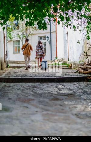 Young multiracial couple is visiting an old city. They are walking through an alley Stock Photo