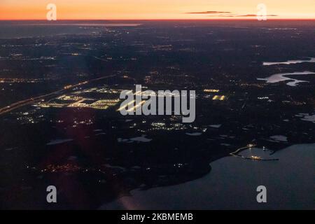 Aerial panoramic view during dusk - sunset time or magic hour of the New Istanbul Airport illuminated from an airplane during a flight on April 12, 2020 in Istanbul, Turkey. Istanbul Airport, Istanbul Havaliman?, IST LTFM is the main international airport of Istanbul, Turkey located at Arnavutkoy district on the European side of the city. It was opened on April 6, 2019 and all the flights from Istanbul Ataturk airport are transferred there. The airport is a hub for Turkish Airlines and Onur Air. When the airport will be completed it will be able to accommodate 200 million passengers a year. (P Stock Photo