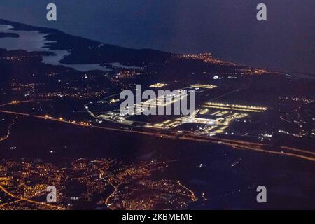 Aerial panoramic view during dusk - sunset time or magic hour of the New Istanbul Airport illuminated from an airplane during a flight on April 12, 2020 in Istanbul, Turkey. Istanbul Airport, Istanbul Havaliman?, IST LTFM is the main international airport of Istanbul, Turkey located at Arnavutkoy district on the European side of the city. It was opened on April 6, 2019 and all the flights from Istanbul Ataturk airport are transferred there. The airport is a hub for Turkish Airlines and Onur Air. When the airport will be completed it will be able to accommodate 200 million passengers a year. (P Stock Photo