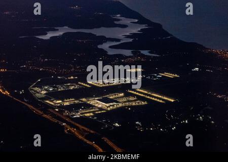 Aerial panoramic view during dusk - sunset time or magic hour of the New Istanbul Airport illuminated from an airplane during a flight on April 12, 2020 in Istanbul, Turkey. Istanbul Airport, Istanbul Havaliman?, IST LTFM is the main international airport of Istanbul, Turkey located at Arnavutkoy district on the European side of the city. It was opened on April 6, 2019 and all the flights from Istanbul Ataturk airport are transferred there. The airport is a hub for Turkish Airlines and Onur Air. When the airport will be completed it will be able to accommodate 200 million passengers a year. (P Stock Photo