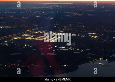 Aerial panoramic view during dusk - sunset time or magic hour of the New Istanbul Airport illuminated from an airplane during a flight on April 12, 2020 in Istanbul, Turkey. Istanbul Airport, Istanbul Havaliman?, IST LTFM is the main international airport of Istanbul, Turkey located at Arnavutkoy district on the European side of the city. It was opened on April 6, 2019 and all the flights from Istanbul Ataturk airport are transferred there. The airport is a hub for Turkish Airlines and Onur Air. When the airport will be completed it will be able to accommodate 200 million passengers a year. (P Stock Photo