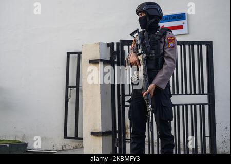 An armed policeman stands guard in front of the mortuary of Bhayangkara Hospital, Palu City, Central Sulawesi Province, Indonesia on April 16, 2020. The police conducted an autopsy to confirm the identities of two members of Poso Timur Indonesia Mujahidin (MIT) who were shot dead after trying to seize police weapons on duty at one of the banks in Poso District, Central Sulawesi Province on April 15, 2020. Local security authorities formed a security task force coded as Operation Tinombala which was tasked with hunting dozens of MIT members hiding in the forests and mountains. Since the communa Stock Photo