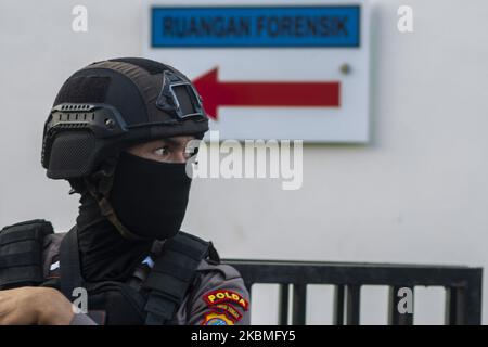 An armed policeman stands guard in front of the mortuary of Bhayangkara Hospital, Palu City, Central Sulawesi Province, Indonesia on April 16, 2020. The police conducted an autopsy to confirm the identities of two members of Poso Timur Indonesia Mujahidin (MIT) who were shot dead after trying to seize police weapons on duty at one of the banks in Poso District, Central Sulawesi Province on April 15, 2020. Local security authorities formed a security task force coded as Operation Tinombala which was tasked with hunting dozens of MIT members hiding in the forests and mountains. Since the communa Stock Photo