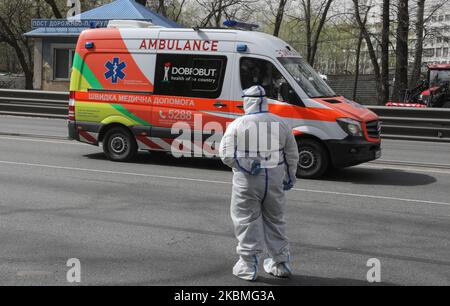 An Ambulance drives past the epidemiologist at the checkpoint in Kyiv, Ukraine, April 16, 2020. Checkpoints at major entrances to Kyiv, established several weeks ago, have been enhanced by thermometry points to measure the body temperature of the drivers and passengers entering Kyiv to prevent the spread of coronavirus (Photo by Sergii Kharchenko/NurPhoto) Stock Photo