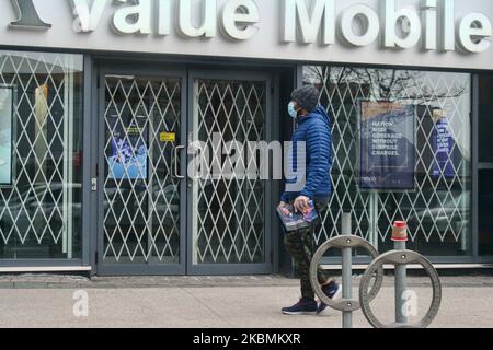 Man wearing a face mask to protect him from the novel coronavirus (COVID-19) as he walks by a shop closed as a result of the virus in Toronto, Ontario, Canada on April 17, 2020. (Photo by Creative Touch Imaging Ltd./NurPhoto) Stock Photo