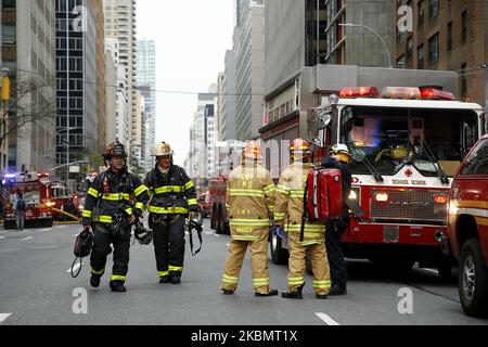 Emergency Services Rescue Personnel and Firemen in New York, on April 23, 2020. New York Fire Department and Emergency services technicians were dispatched to a high-rise in New York City on April 23, 2020. Scores of firetrucks, ambulances and EMT rescue medics stood ready in front of Murray Hill towers on 2nd Avenue. (Photo by John Lamparski/NurPhoto) Stock Photo