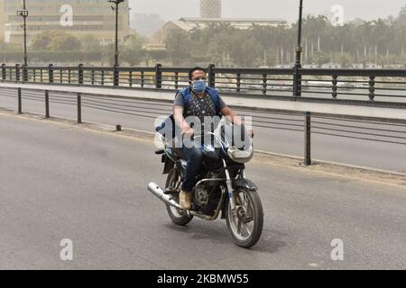 A man wearing face mask rides a motorcycle during a sandstorm in Cairo, Egypt, 24 April 2020 (Photo by Ziad Ahmed/NurPhoto) Stock Photo