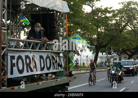 Truck with a flag that reads 'Fora Doria' and with supporters of far-right Brazilian President Jair Bolsonaro lead motorcade to protest against the recommendations for social isolation of the Governor of Sao Paulo Joao Doria and to re-open business shut down during the coronavirus disease (COVID-19) outbreak in Santos, Brazil, April 26, 2020. (Photo by Felipe Beltrame/NurPhoto) Stock Photo