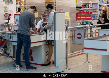 A couple in protective face masks is seen shopping in Auchan supermarket during first days of a slight ease of lockdown during Covid-19 pandemic in Krakow, Poland on April 27, 2020. After few weeks of strict lockdown the policy relaxes but Poles must still keep distance and wear protective face masks at all times while in public. (Photo by Dominika Zarzycka/NurPhoto) Stock Photo