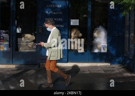 A man walks a front a two Teddy bears who drink a glass of champagne inside a closed cafe in the 'Les Gobelins' area in Paris, as a lockdown is imposed to slow the rate of the coronavirus disease (COVID-19) in France, April 27, 2020. (Photo by Mehdi Taamallah/NurPhoto) Stock Photo