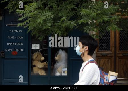 A man walks a front a two Teddy bears who drink a glass of champagne inside a closed cafe in the 'Les Gobelins' area in Paris, as a lockdown is imposed to slow the rate of the coronavirus disease (COVID-19) in France, April 27, 2020. (Photo by Mehdi Taamallah/NurPhoto) Stock Photo