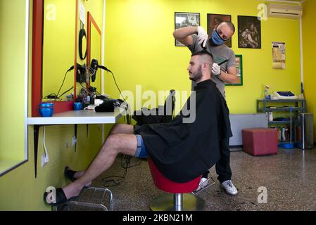 The hairdresser with protective mask and gloves cuts the client's hair after the reopening during the coronavirus disease (COVID-19) in Belgrade, Serbia on April 28, 2020. Serbian President Aleksandar Vucic had declared the state of emergency to stop the spread of the coronavirus. Following the drop in the number of coronavirus patients the government from this week allows the reopening of hairdressers, gyms and markets. (Photo by Nikola Krstic/NurPhoto)