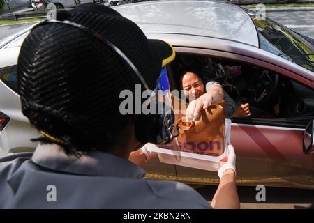 A McDonald's customer picking up her order from drive-thru service point as a preventive measure against the coronavirus (Covid-19) at McDonald cafe Kanchanaphisek-Kanlapaphruek branch on April 29, 2020 in Bangkok, Thailand. As Bangkok metropolitan administration plans to unlocking and reopening restaurants from strict epidemic prevention measures after the number of new infections continues to decline. (Photo by Vachira Vachira/NurPhoto) Stock Photo