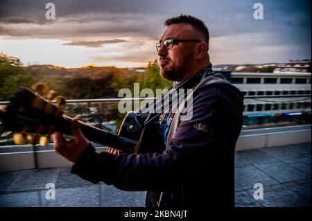 Deyan Stoev rehearses before live streaming. Musicians are organizing secret concerts on balconies in Varna, Bulgaria every Thursday. The musicians self-organized and choose different balconies of apartament buildings around the city to lift the spirits of the neighborhoods during quarantine. They also live stream them on the social medias for the people, Varna, Bulgaria on April 30, 2020 (Photo by Hristo Rusev/NurPhoto) Stock Photo