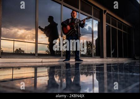 Deyan Stoev rehearses before live streaming. Musicians are organizing secret concerts on balconies in Varna, Bulgaria every Thursday. The musicians self-organized and choose different balconies of apartament buildings around the city to lift the spirits of the neighborhoods during quarantine. They also live stream them on the social medias for the people, Varna, Bulgaria on April 30, 2020 (Photo by Hristo Rusev/NurPhoto) Stock Photo