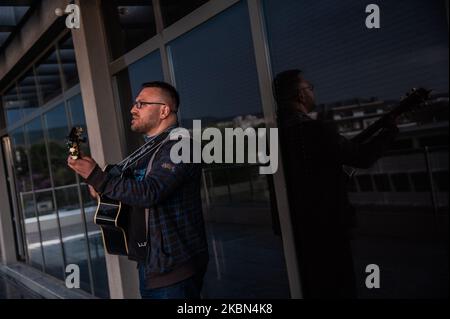 Deyan Stoev rehearses before live streaming. Musicians are organizing secret concerts on balconies in Varna, Bulgaria every Thursday. The musicians self-organized and choose different balconies of apartament buildings around the city to lift the spirits of the neighborhoods during quarantine. They also live stream them on the social medias for the people, Varna, Bulgaria on April 30, 2020 (Photo by Hristo Rusev/NurPhoto) Stock Photo