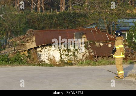 A firefighter care to rusted old house near forest burning site in Goseong, some 160 kilometers northeast of Seoul, on May 2, 2020. The fire broke out a day earlier. A fire broke out late Friday near a mountain in Goseong, Gangwon Province, forcing at least dozens of people to evacuate and local authorities to call for help from nearby cities. No casualty had been reported as of 10:20 p.m., but the fire was growing quickly due to strong winds, local rescue workers said. The fire began at a house in the county located some 210 kilometers northeast of Seoul, and later spread to a nearby forest o Stock Photo