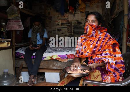 Noorekha Malik sits inside her shanty in Gurugram on the outskirts of New Delhi, India on 06 May 2020. Noorekha Malik, 32, who had to maintain a house in Gurugram, is with her son, 13, Shiraz Malik. With no work for them, theyâ€™re being left to fend for themselves amid the lockdown after Noorekhaâ€™s husband Imran Malik left for Kolkata on March 14. â€œWeâ€™re missing him. Although he had been in touch with us on the phone weâ€™re uncertain. Heâ€™s running out of money and so as we and what if this lockdown extended we might die hungry.â€ (Photo by Nasir Kachroo/NurPhoto) Stock Photo