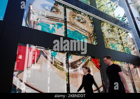 People walk past digital displays supporting health workers in the windows of clothing retailer Flannels on a near-deserted Oxford Street in London, England, on May 6, 2020. Britain is now well into its seventh week of coronavirus lockdown, although a slight easing of the restrictions is expected to be announced this Sunday, along with a schedule for further 'easements' over the coming months. Covid-19 deaths across the country have meanwhile reached 30,076 according to today's figures from the UK's Department of Health and Social Care. The figure is currently considered to be the highest in E Stock Photo