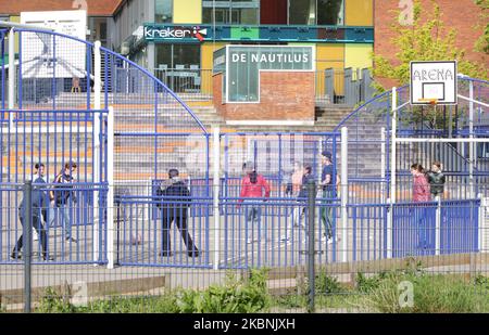 Students are seen play football at the public elementary school De Notenkraker during school reopening amid the Coronavirus pandemic May 11, 2020 in Amsterdam,Netherlands.The Dutch Government authorized the reopening of primary schools and respecting the rules observed of the social distance. Research showed over a third of primary school teachers think reopening schools is too risky, and the risk of children spreading coronavirus is major worry. (Photo by Paulo Amorim/NurPhoto) Stock Photo