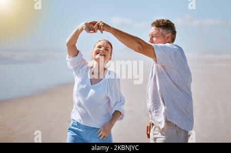 Happy senior couple, dancing and beach for summer vacation, romance or bonding together in the outdoors. Elderly man and woman with smile for romantic Stock Photo