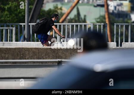 A cyclist rides his bicycle on the road during rush hour at Sathorn bridge on May 12, 2020 in Bangkok, Thailand. (Photo by Vachira Vachira/NurPhoto) Stock Photo