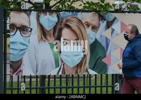 A man walks by a banner 'Thank you To Healthcare Professionals' in Krakow center seen on the on International Nurses Day. On Tuesday, May 12, 2020, in Krakow, Poland. (Photo by Artur Widak/NurPhoto) Stock Photo