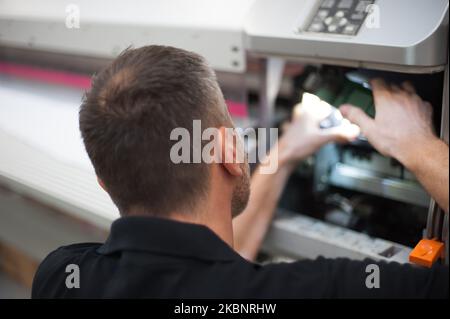 All machines nead maintains. Professional technician troubleshooting and repair the machines in the printing house. Stock Photo