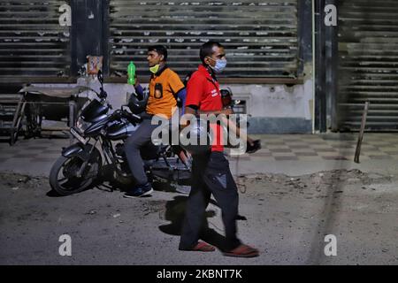 A Zomato Food delivery boy wawlks past an Swiggy delivery boy in Gurugram on the outskirts of New Delhi, India on 15 May 2020. Indian food delivery startup Zomato cuts 13% of workforce (Photo by Nasir Kachroo/NurPhoto) Stock Photo