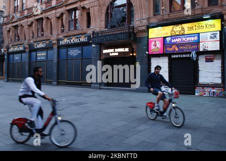 Two men on 'Boris Bikes' ride past the shuttered Hippodrome Casino in Leicester Square in London, England, on May 15, 2020. Nearly eight full weeks have now passed since British Prime Minister Boris Johnson ordered the country's coronavirus lockdown on March 23, although across England some of the measures, including the restriction on exercising outdoors more than once a day, have this week been removed. As the country emerges from lockdown, cycling is being encouraged across London as a way to move around without relying unduly on public transport. (Photo by David Cliff/NurPhoto) Stock Photo