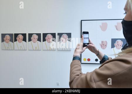 A lady takes a picture of paintings, a piece of art related to Jean Paul II, a part of 'The Pope' current exhibition of the Museum of Contemporary Art in Krakow MOCAK. On May 15, 2020, in Krakow, Poland. (Photo by Artur Widak/NurPhoto) Stock Photo