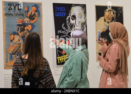 Visitors look at Nazi anti-semitic posters addressed to Poles, a part of World War II – Drama, Symbol, Trauma exhibition, in the Museum of Contemporary Art MOCAK, in Krakow. On May 16, 2020, in Krakow, Poland. (Photo by Artur Widak/NurPhoto) Stock Photo