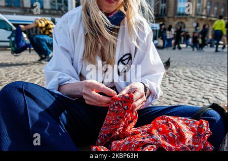 A XR activist is sewing used clothes, during a XR action against fast fashion industry in Amsterdam, on May 22nd, 2020. (Photo by Romy Arroyo Fernandez/NurPhoto) Stock Photo