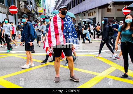 One Hong Kong street protester is draped with the United States of America flag during the 24th May protests in the Causeway Bay district in Hong Kong, China, on Sunday, May 24, 2020. (Photo by Tommy Walker/NurPhoto) Stock Photo
