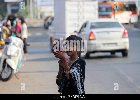 A Muslim girl applies make-up alongside a road during Eid al-Fitr in Mumbai, India on May 25, 2020. Eid al-Fitr marks the end of the holy month of Ramadan which is a month of fasting and prayer. (Photo by Himanshu Bhatt/NurPhoto) Stock Photo