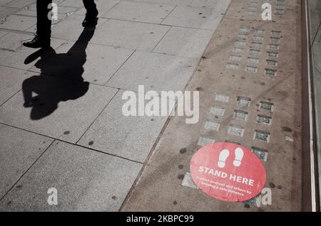 A man walks past social distancing queue markers outside a branch of Halifax bank on a near-deserted New Oxford Street in London, England, on May 28, 2020. The UK is now in its tenth week of coronavirus lockdown, with total deaths now standing at 37,837, according to today's updated count from the Department of Health and Social Care. British Prime Minister Boris Johnson meanwhile remains under unrelenting pressure over his refusal to sack his top aide, Dominic Cummings, who stands accused of flouting strict stay-at-home instructions by driving with his wife and son from London to County Durha Stock Photo