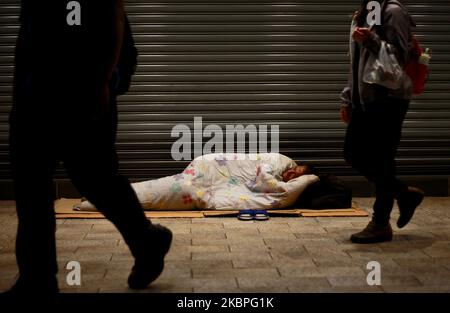 A male homeless person with a blanket lies upon the sidewalk outside a chain store selling commodities, in Ximen, Taipei City of Taiwan on 27 May, 2020, as the coronavirus disease Covid-19 continues (Photo by Ceng Shou Yi/NurPhoto) Stock Photo