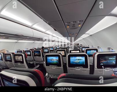 Interior of a cabin in Economy Class of an Airbus A321 NEO during a flight. Flying with Turkish Airlines during the COVID-19 Coronavirus pandemic outbreak era. Fewer passengers are onboard in an almost empty airplane to fly, while passengers cabin crew and flight attendants are wearing protective face masks. The International flight TK 1843 from Istanbul New Airport in Turkey to the capital Athens in Greece is operated by a new modern, sophisticated and advanced aircraft, an Airbus A321neo with registration TC-LSN. (Photo by Nicolas Economou/NurPhoto) Stock Photo