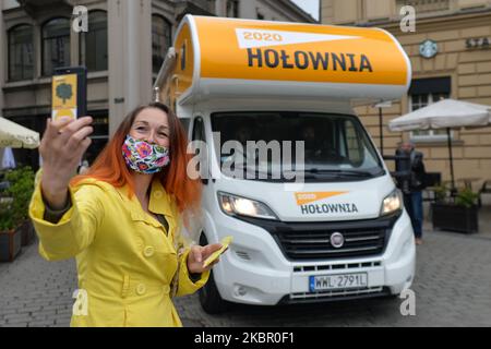 A supporter of Szymon Holownia, an independent candidate for the Presidential Election 2020, takes a selfie in front of Holownia's election campervan, in Krakow's Main Market Square. On June 8, 2020, in Krakow, Lesser Poland Voivodeship, Poland. (Photo by Artur Widak/NurPhoto) Stock Photo