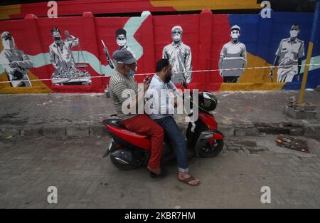 People use mobile phone in front of a mural to pay tribute to frontline workers during the COVID-19 pandemic in Mumbai, India on June 15, 2020. India has begun gradually lifting its restrictions imposed by the government to slow the spread of the Coronavirus (COVID-19) pandemic. (Photo by Himanshu Bhatt/NurPhoto) Stock Photo