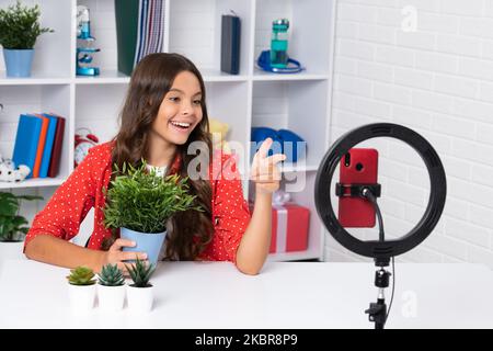 Blogging, videoblog. Teenager child blogger with phone recording video. Influencer teen girl speaking in front of smartphone. Happy girl face Stock Photo