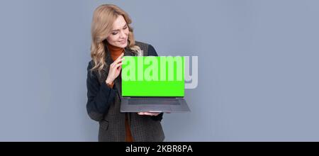 Business woman look at laptop with blank neon green screen for copy space, notebook. Woman portrait, isolated header banner with copy space. Stock Photo