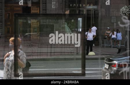 A man waits for a bus at a stop as three girls sit at the table of a cafe in Kyiv, Ukraine, June 17, 2020. The number of Covid-19 confirmed cases begun to rise a week ago. Over the past 24 hours, 758 new cases of coronavirus infection were detected - the largest number since the appearance of SARS-CoV-2 coronavirus in Ukraine, Public Health Center reports. (Photo by Sergii Kharchenko/NurPhoto) Stock Photo