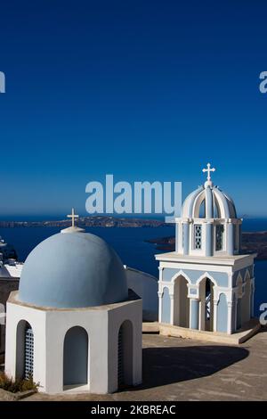 Domes on the rooftop of the Church of St. Mark the Evangelist. Famous stunning view of white panoramic architecture on the cliff and blue dome church above the volcanic caldera, of Santorini volcano at the village of Firostefani, Thira in Santorini island, Aegean Sea, Greece on June 18, 2020. Greece started accepting tourists since June 15 after lifting some lockdown measures and travel ban promoting the Greek summer for holidays. Tourism is one of the largest single market industry for the income of the GDP. (Photo by Nicolas Economou/NurPhoto) Stock Photo