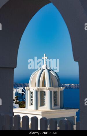Domes on the rooftop of the Church of St. Mark the Evangelist. Famous stunning view of white panoramic architecture on the cliff and blue dome church above the volcanic caldera, of Santorini volcano at the village of Firostefani, Thira in Santorini island, Aegean Sea, Greece on June 18, 2020. Greece started accepting tourists since June 15 after lifting some lockdown measures and travel ban promoting the Greek summer for holidays. Tourism is one of the largest single market industry for the income of the GDP. (Photo by Nicolas Economou/NurPhoto) Stock Photo